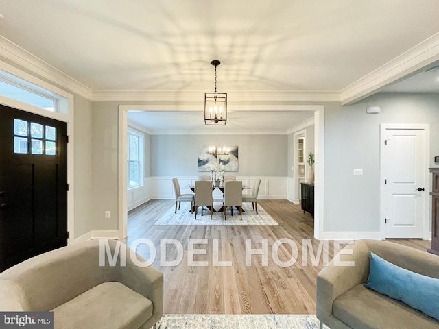 dining area featuring built in features, plenty of natural light, wood-type flooring, a chandelier, and ornamental molding