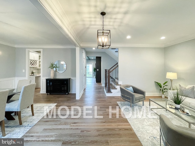 living room featuring a notable chandelier, wood-type flooring, and crown molding