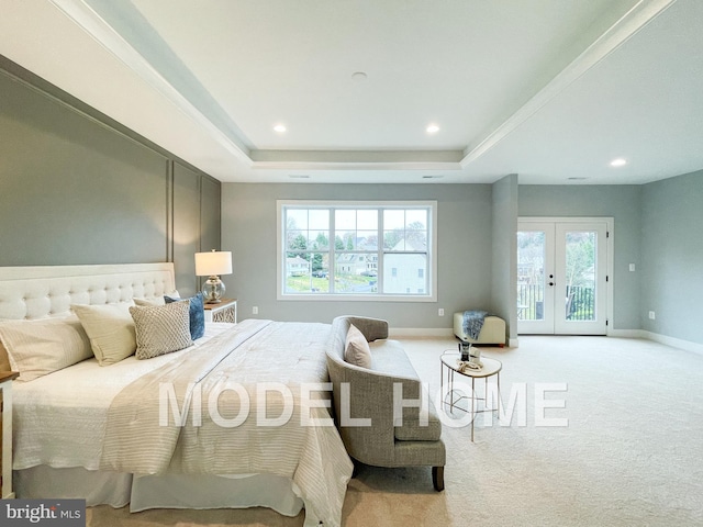 bedroom with a raised ceiling, access to exterior, light carpet, and french doors