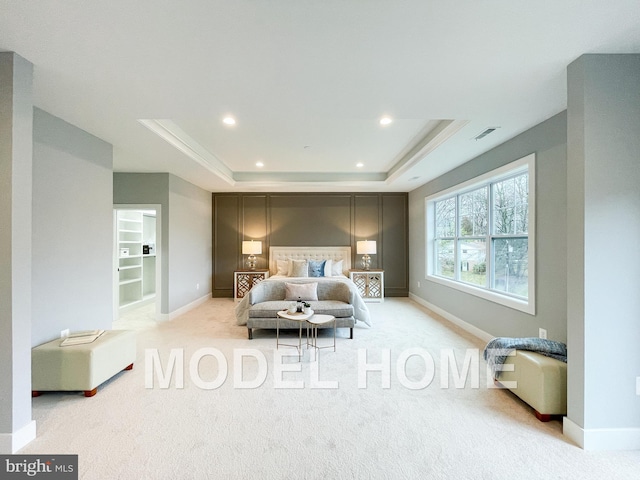 bedroom featuring light carpet and a tray ceiling