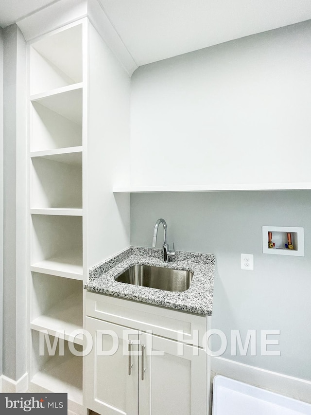 clothes washing area with washer hookup, cabinets, and sink