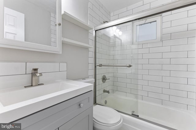 full bathroom with shower / bath combination with glass door, toilet, and vanity