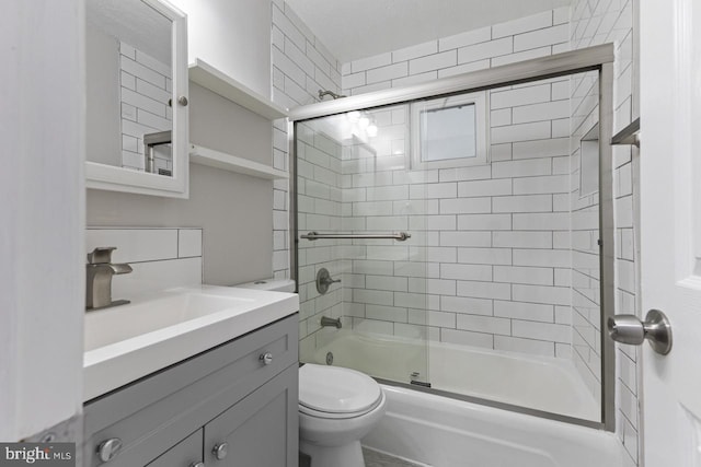 full bathroom with vanity, toilet, and bath / shower combo with glass door