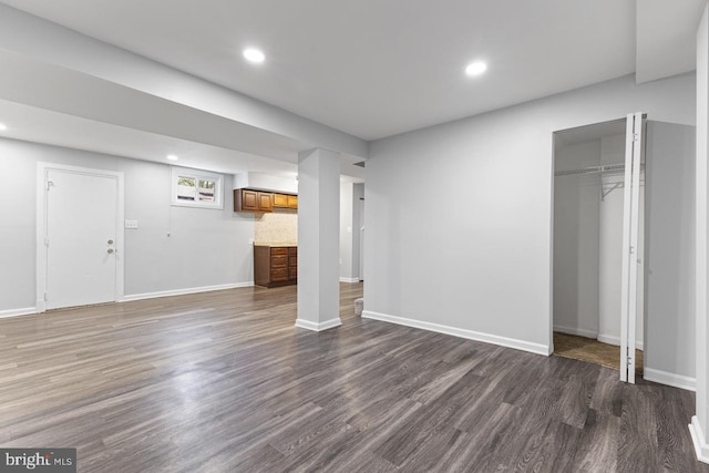 basement with dark hardwood / wood-style floors