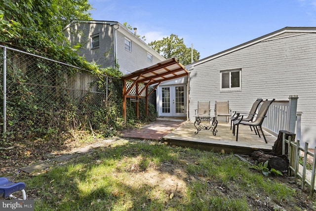 rear view of house featuring a pergola, a deck, and french doors