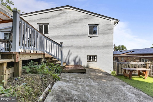 back of property featuring a wooden deck and a patio area