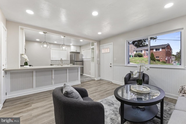 living room with sink and light hardwood / wood-style flooring