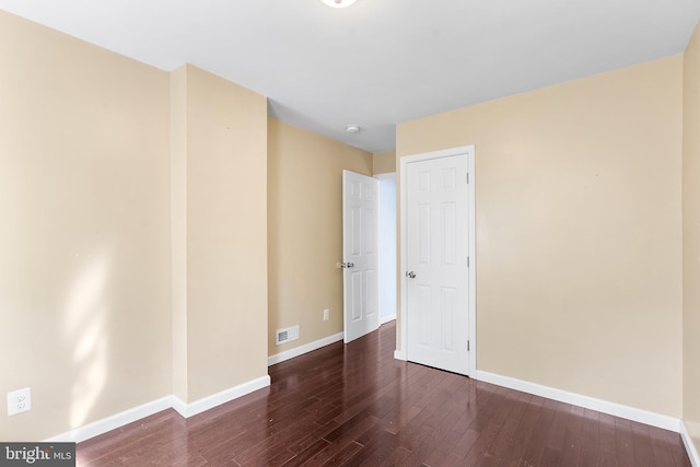 unfurnished room with dark wood-type flooring