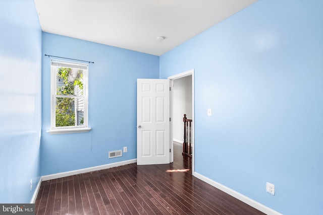 empty room with dark hardwood / wood-style flooring