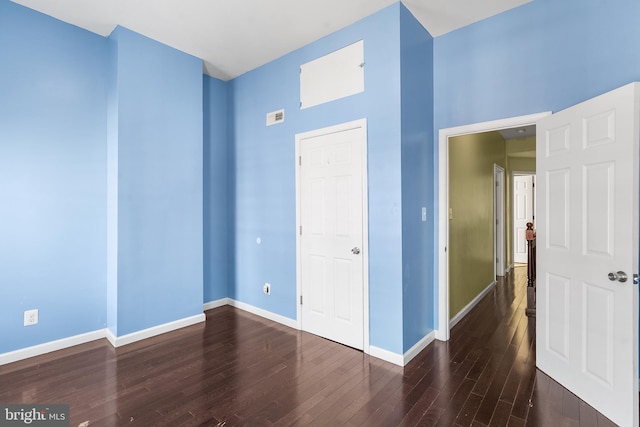 unfurnished bedroom with dark hardwood / wood-style flooring