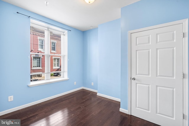 unfurnished room featuring dark hardwood / wood-style flooring