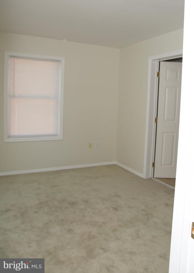 spare room featuring light colored carpet