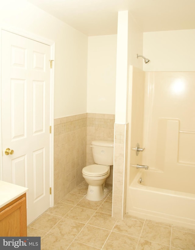 full bathroom featuring bathtub / shower combination, tile walls, tile patterned flooring, vanity, and toilet