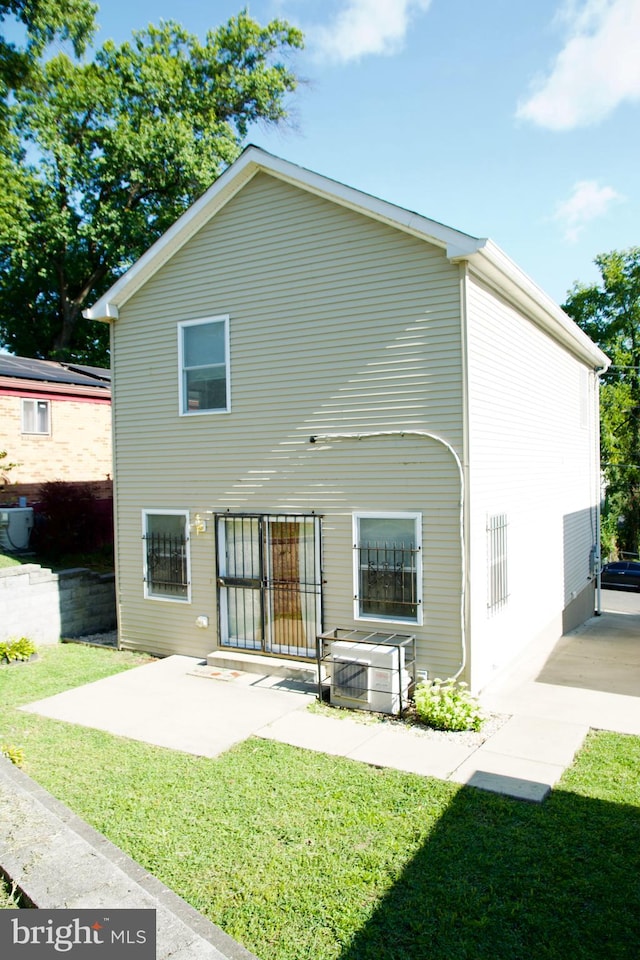 rear view of house with a lawn and a patio area