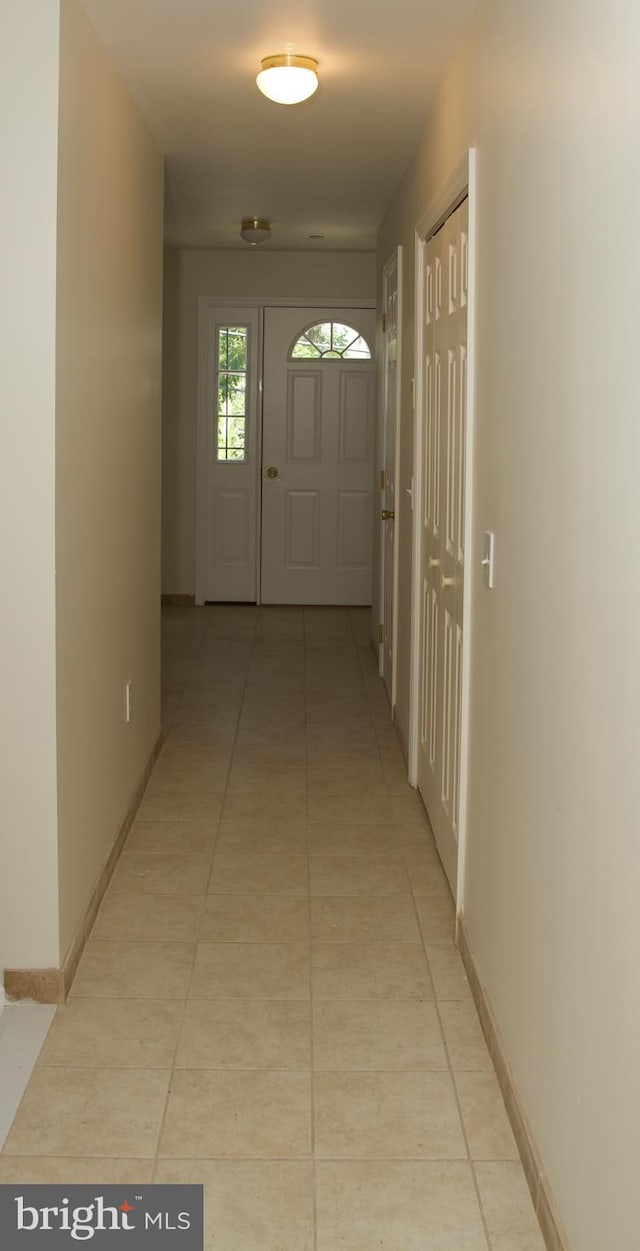 hall with light tile patterned floors