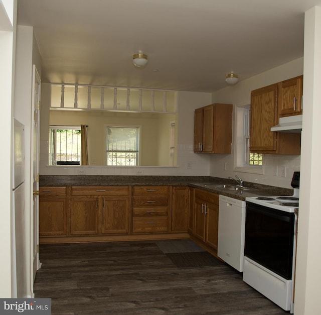 kitchen featuring kitchen peninsula, dark hardwood / wood-style flooring, white appliances, and decorative backsplash