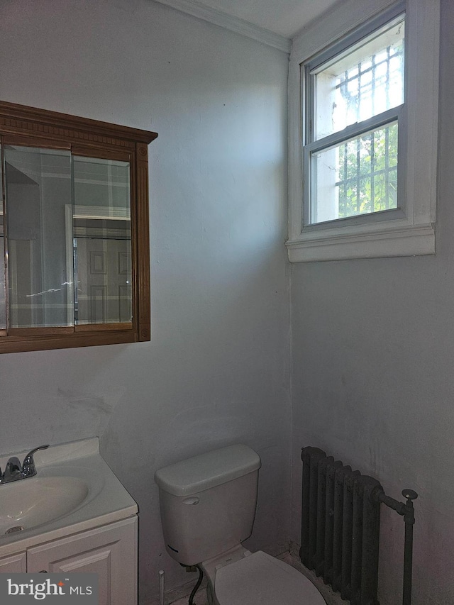 bathroom with toilet, crown molding, radiator heating unit, and vanity