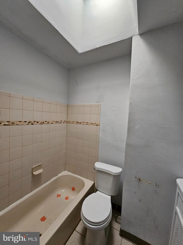 bathroom featuring a bathtub, toilet, and tile patterned flooring