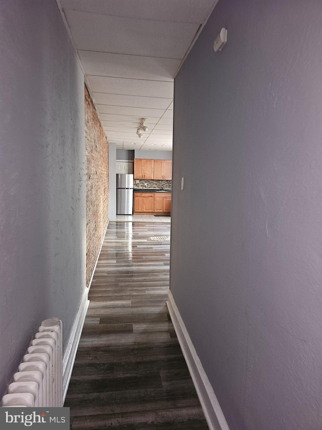 hall with radiator heating unit and dark hardwood / wood-style flooring