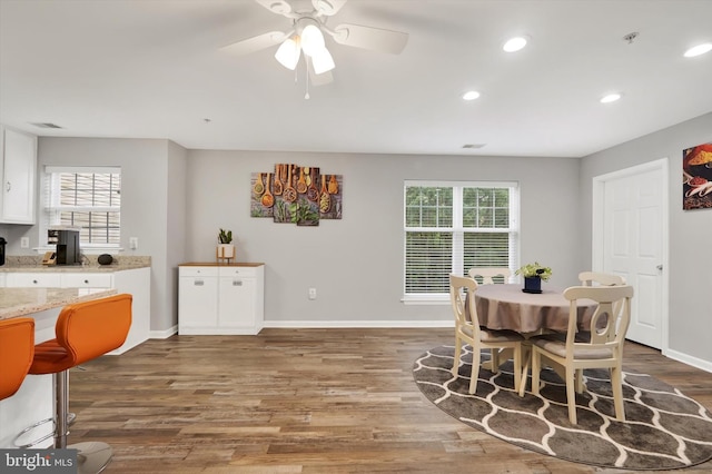 dining area featuring ceiling fan, wood-type flooring, and a healthy amount of sunlight