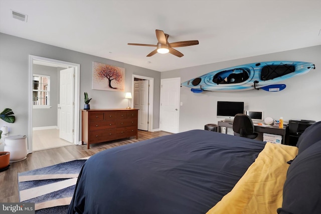 bedroom featuring light wood-type flooring, ensuite bath, and ceiling fan