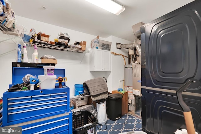 laundry room featuring gas water heater and stacked washer / drying machine