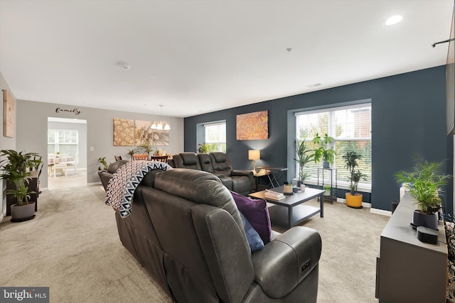 carpeted living room with a chandelier and a wealth of natural light