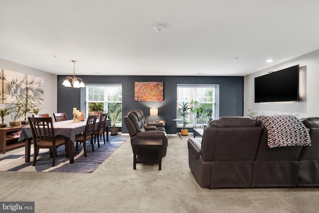 carpeted living room featuring a notable chandelier