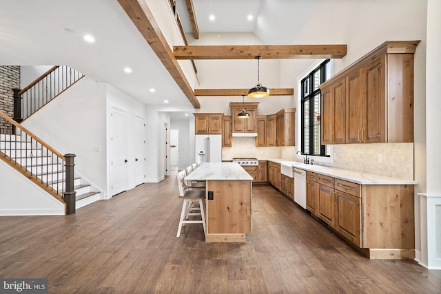 kitchen featuring white appliances, a kitchen island, dark hardwood / wood-style floors, and tasteful backsplash