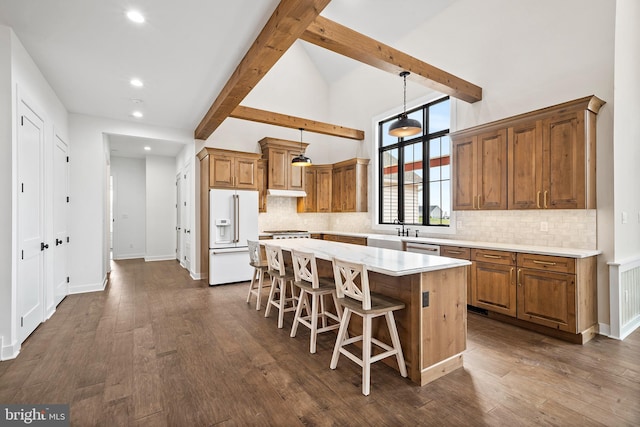 kitchen with high end white fridge, a kitchen island, hanging light fixtures, dark hardwood / wood-style floors, and beam ceiling