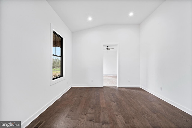 empty room with ceiling fan, vaulted ceiling, and dark hardwood / wood-style flooring