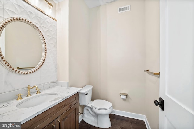 bathroom with vanity, toilet, and hardwood / wood-style floors