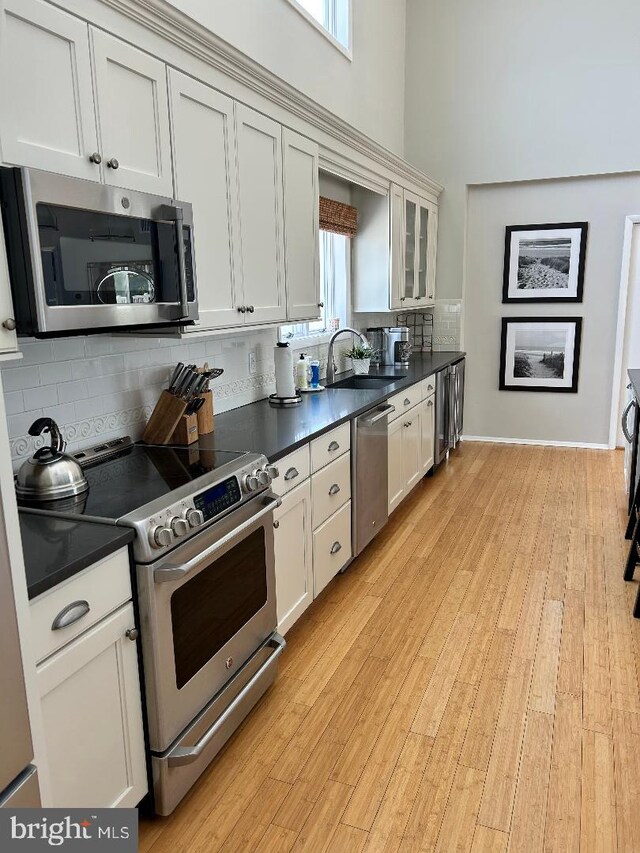 kitchen with pendant lighting, white cabinets, a kitchen bar, and hardwood / wood-style floors