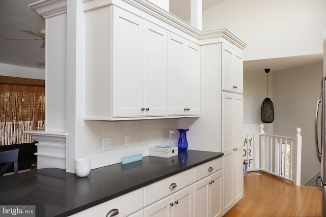 kitchen featuring pendant lighting, light hardwood / wood-style floors, and white cabinetry