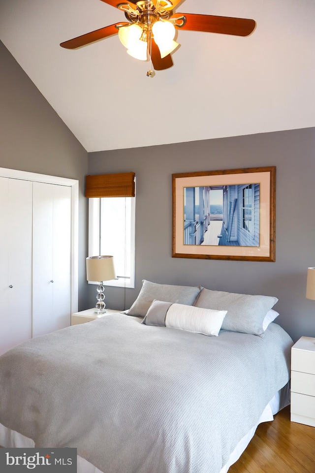 bedroom with a closet, lofted ceiling, ceiling fan, and hardwood / wood-style floors