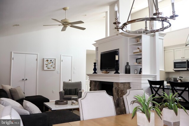 living room with ceiling fan, hardwood / wood-style flooring, and lofted ceiling