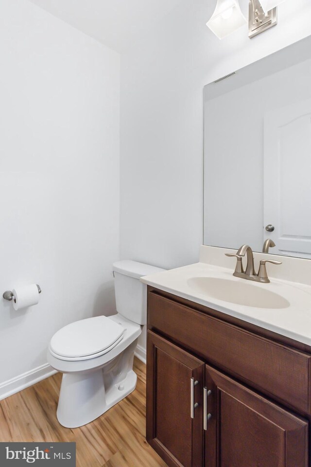 bathroom featuring hardwood / wood-style flooring, vanity, and toilet