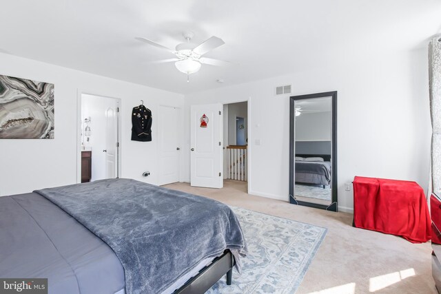 carpeted bedroom with connected bathroom and ceiling fan