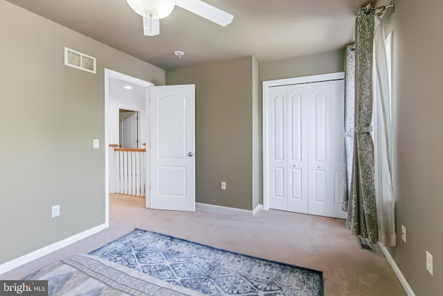 unfurnished bedroom featuring carpet, ceiling fan, and a closet