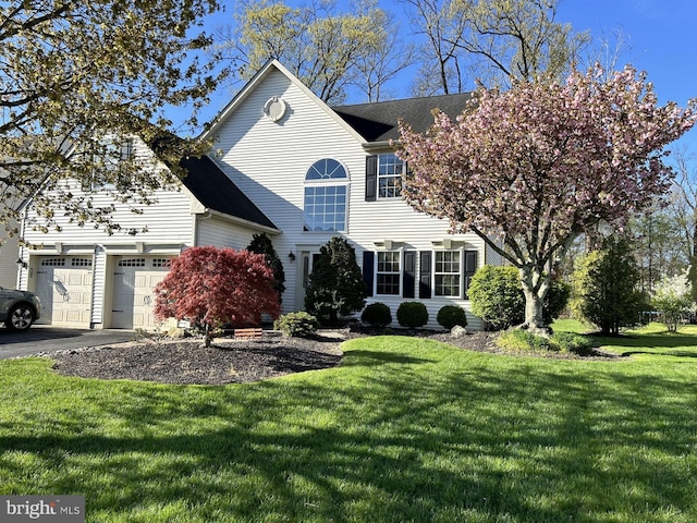 view of front of property with a front yard and a garage