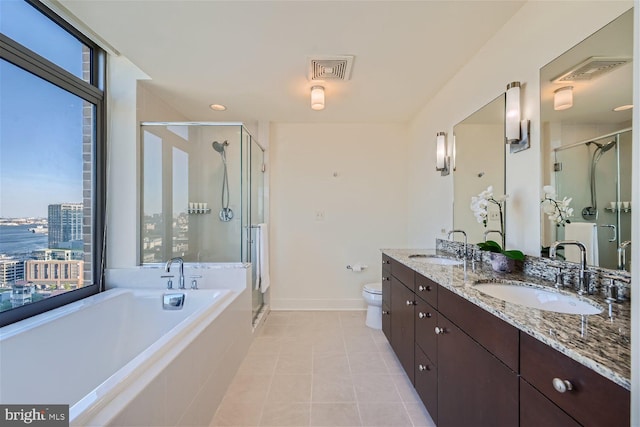 full bathroom with a water view, tile patterned floors, separate shower and tub, vanity, and toilet