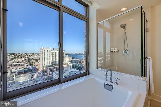 bathroom with shower with separate bathtub and a water view