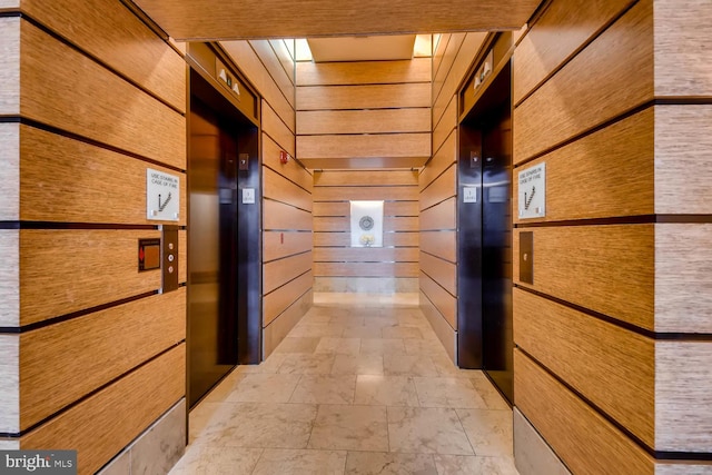 hall featuring wood walls and elevator