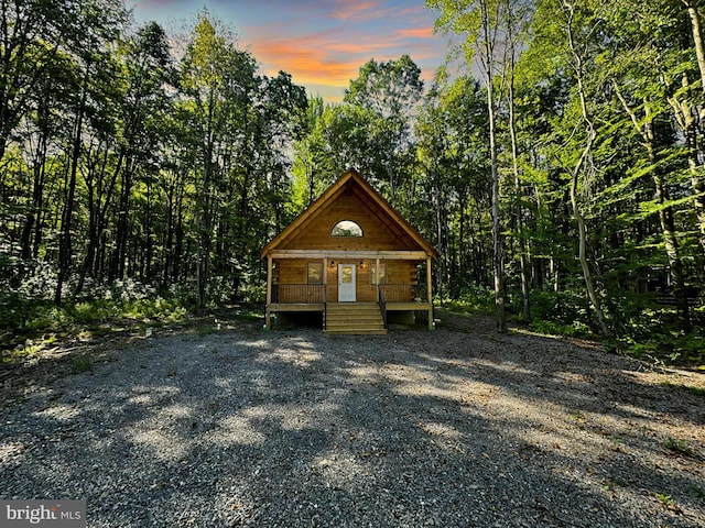 outdoor structure at dusk featuring covered porch