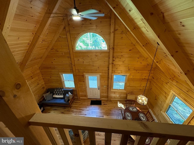 interior space with ceiling fan, wooden walls, high vaulted ceiling, and wooden ceiling