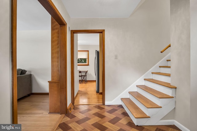 stairway featuring parquet flooring