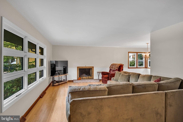 living room featuring light hardwood / wood-style flooring, a chandelier, and a fireplace