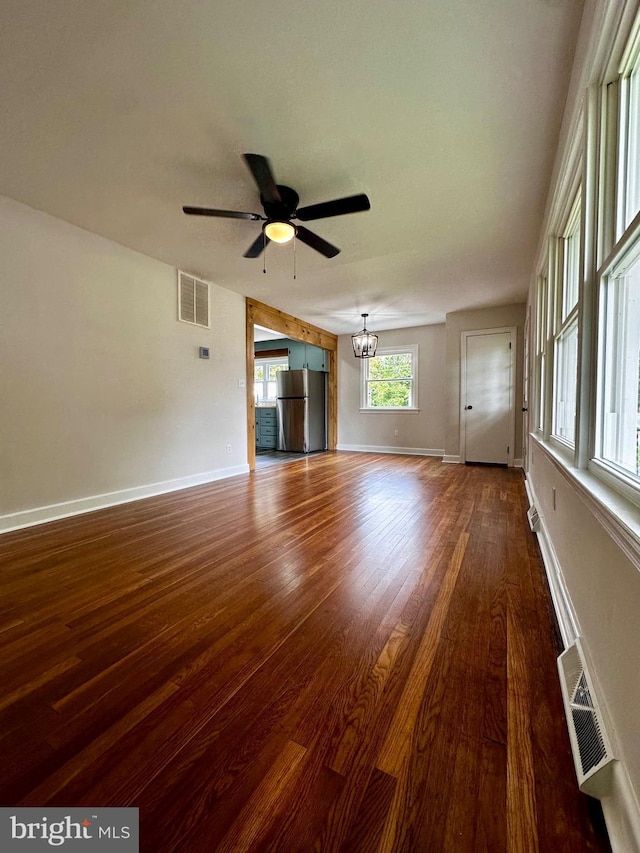 1315 Lexington St, Salisbury, MD 21804 - unfurnished living room featuring dark wood-style floors, ceiling fan with notable chandelier, baseboards, and visible vents