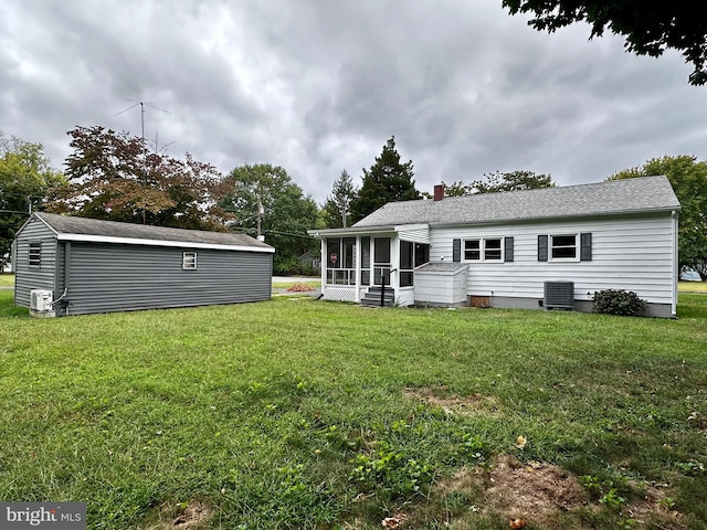 1315 Lexington St, Salisbury, MD 21804 - back of property with an outdoor structure, a sunroom, roof with shingles, a lawn, and a chimney