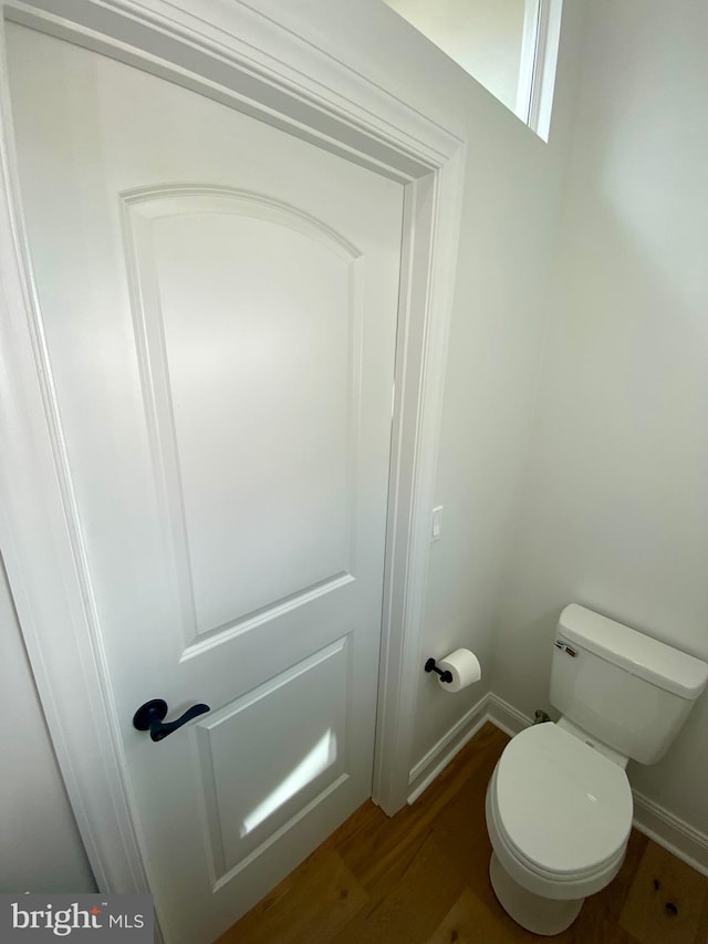 bathroom featuring wood-type flooring and toilet